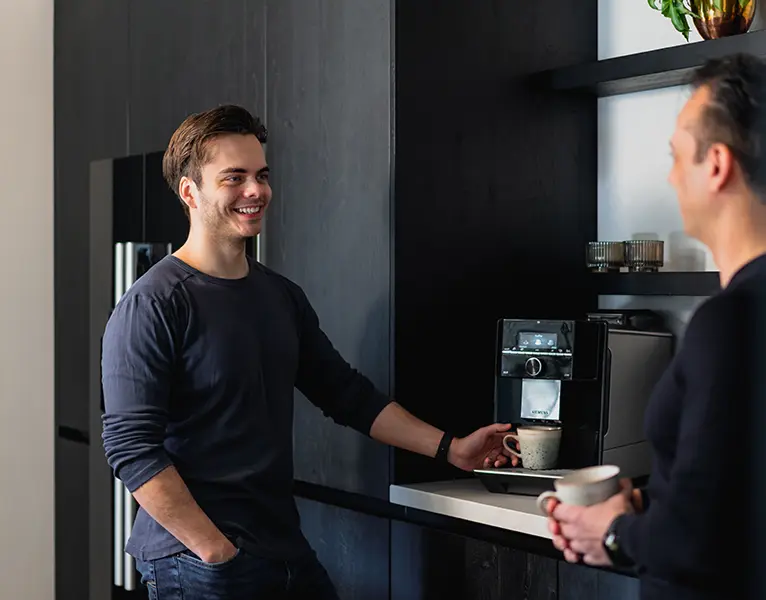 Jesse Hof lacht tijdens een koffiemoment met een klant